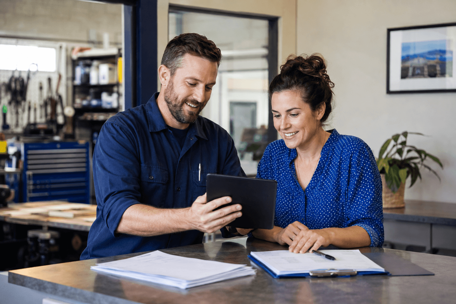 A service business owner and coordinator reviewing business records